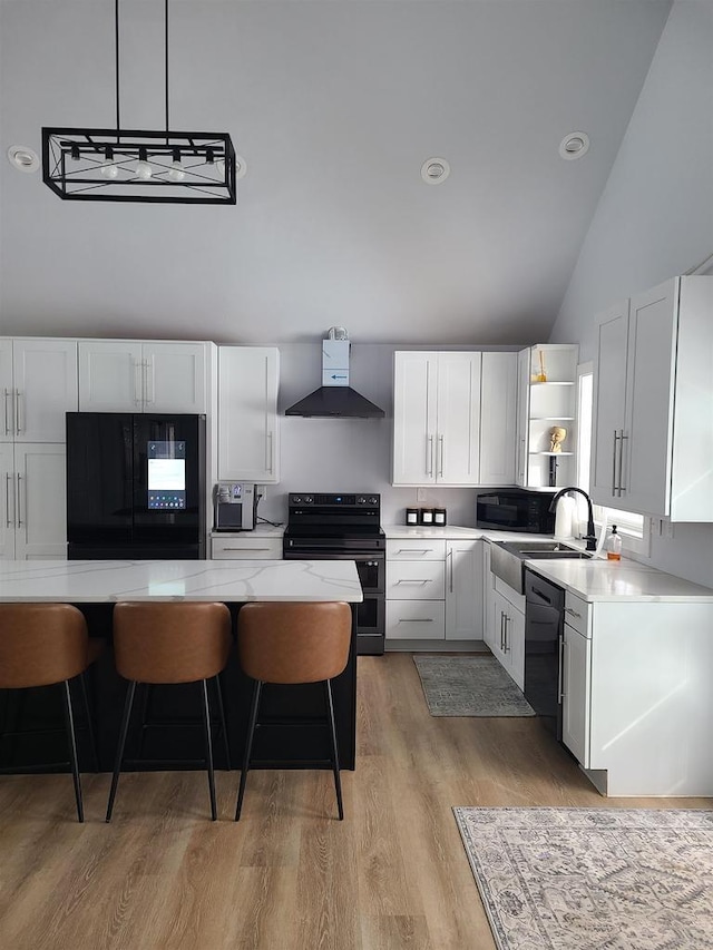 kitchen featuring sink, white cabinetry, black appliances, a kitchen bar, and wall chimney exhaust hood