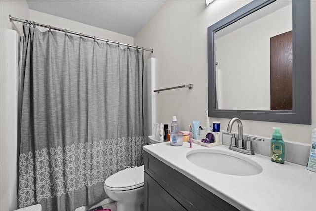 bathroom with vanity, toilet, and a textured ceiling