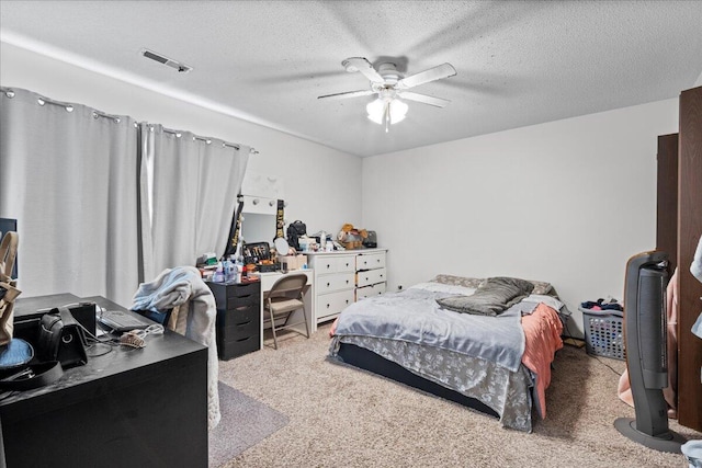 carpeted bedroom featuring ceiling fan and a textured ceiling