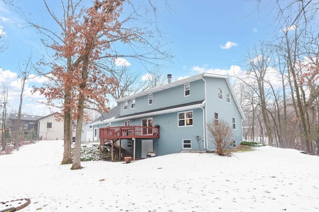 snow covered house with a wooden deck