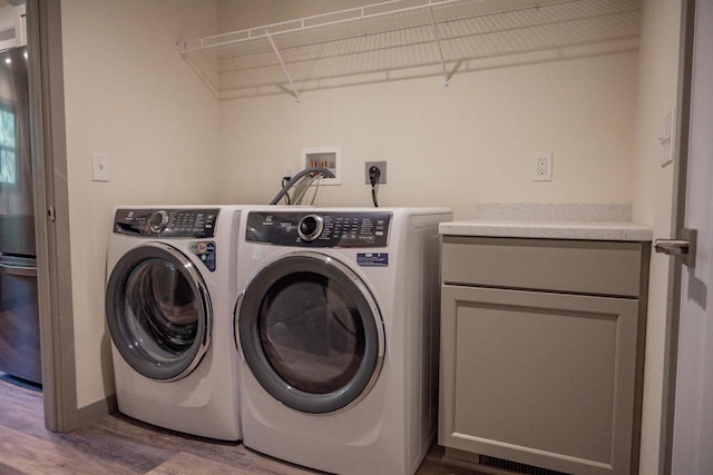 laundry room featuring washer and dryer and hardwood / wood-style floors