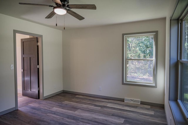 empty room with ceiling fan and dark hardwood / wood-style floors