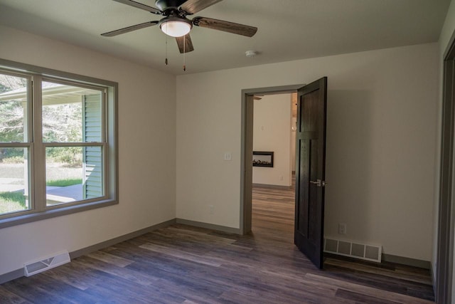 empty room with dark hardwood / wood-style floors and ceiling fan