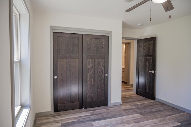 unfurnished bedroom with ceiling fan, hardwood / wood-style floors, and a closet