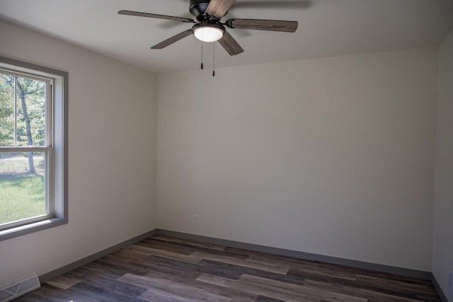 empty room with dark hardwood / wood-style flooring, ceiling fan, and a healthy amount of sunlight