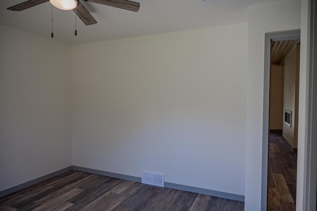 empty room with dark hardwood / wood-style floors and ceiling fan