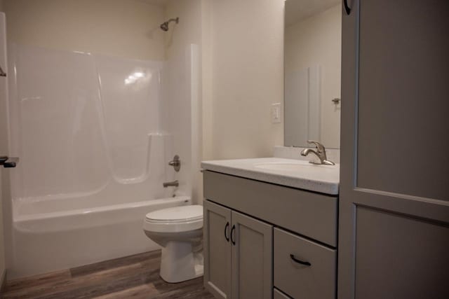 full bathroom with vanity, hardwood / wood-style floors, shower / bathtub combination, and toilet