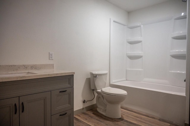 full bathroom featuring hardwood / wood-style flooring, vanity, bathtub / shower combination, and toilet