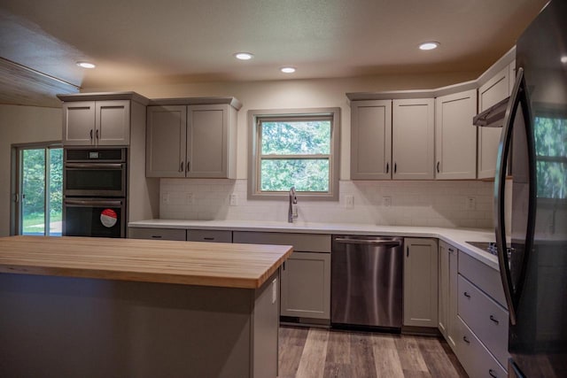 kitchen featuring appliances with stainless steel finishes, sink, gray cabinets, and wooden counters