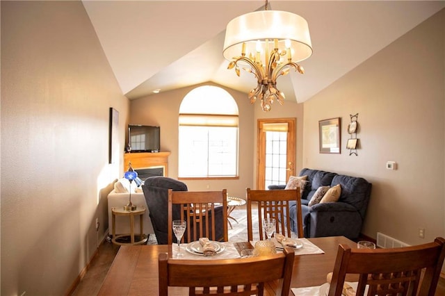 dining room featuring an inviting chandelier, wood-type flooring, and vaulted ceiling