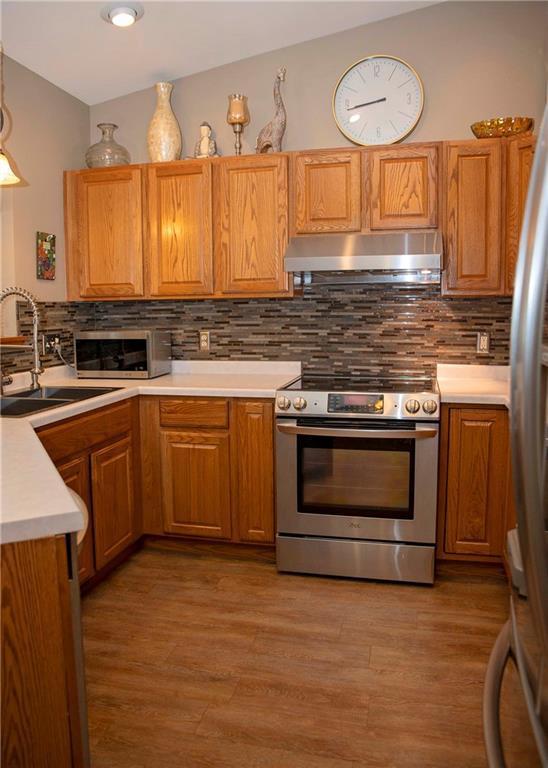 kitchen featuring tasteful backsplash, appliances with stainless steel finishes, sink, and light wood-type flooring