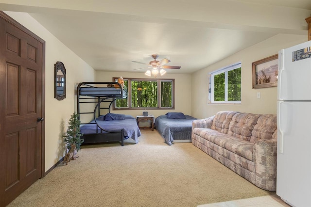 carpeted bedroom with ceiling fan and white fridge