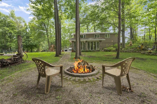 view of yard featuring a playground and an outdoor fire pit