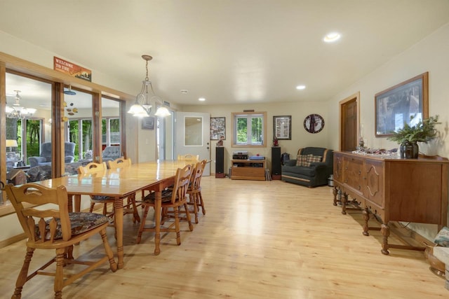 dining space with a healthy amount of sunlight, a chandelier, and light hardwood / wood-style flooring