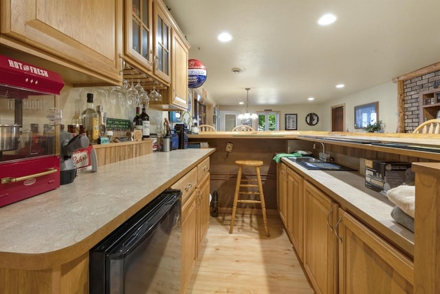 bar featuring hanging light fixtures, sink, beverage cooler, and light wood-type flooring