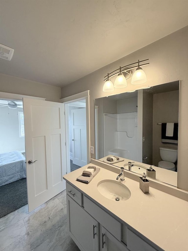 bathroom with vanity, a shower, and toilet