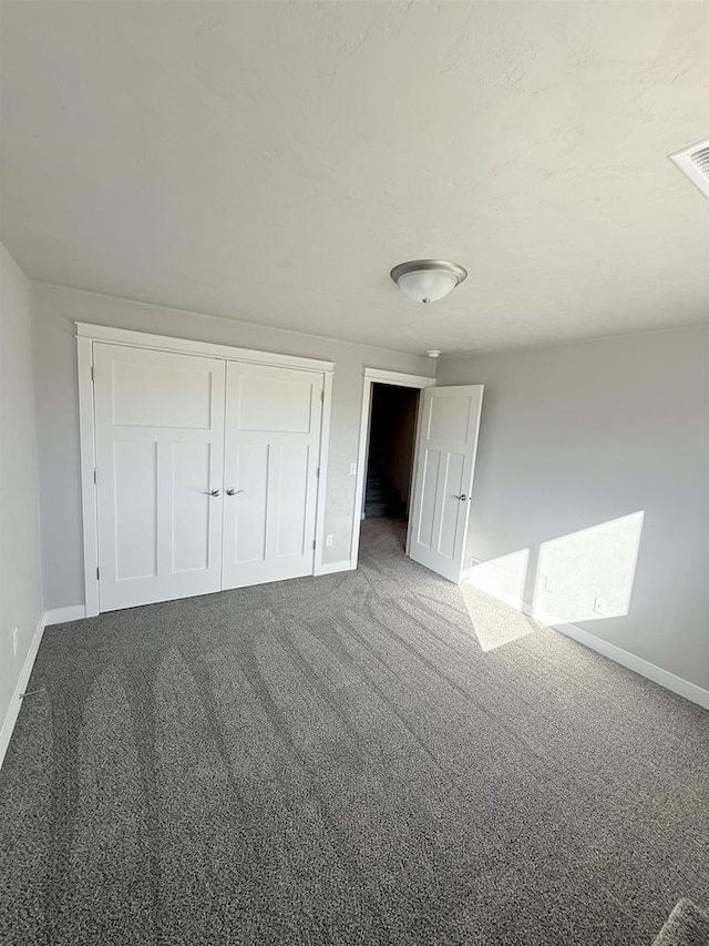 unfurnished bedroom featuring carpet flooring and a closet