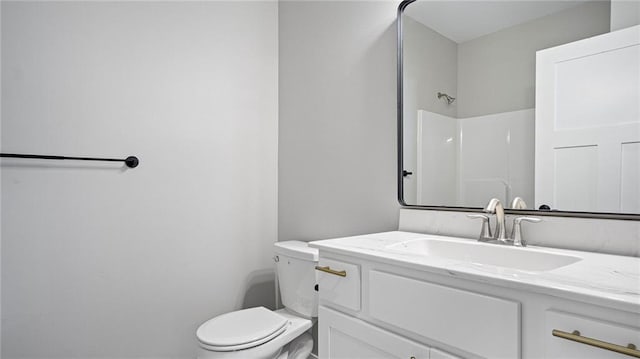 bathroom with vanity, a shower, and toilet