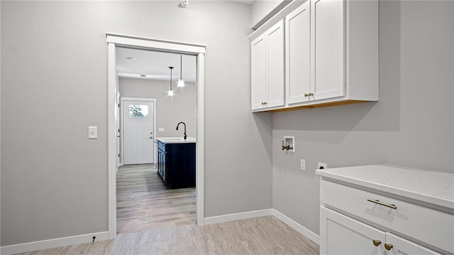 washroom featuring cabinets, washer hookup, sink, and electric dryer hookup