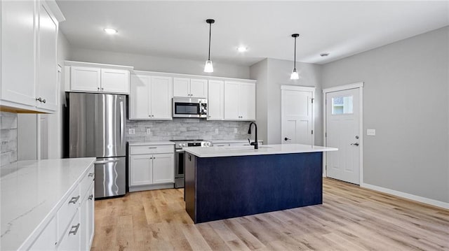 kitchen with pendant lighting, sink, white cabinetry, and stainless steel appliances