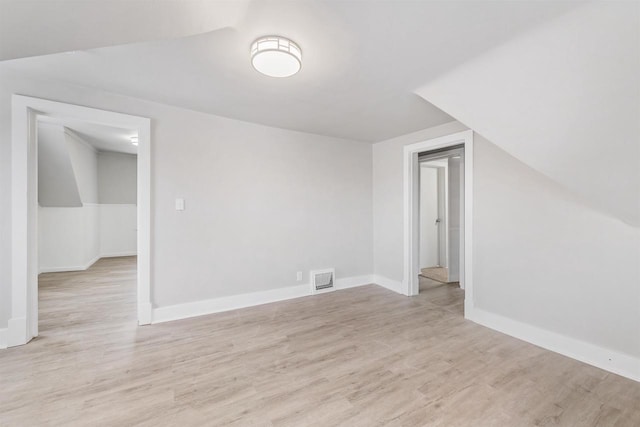 bonus room with lofted ceiling and light hardwood / wood-style flooring