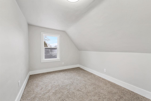 additional living space featuring lofted ceiling and carpet floors