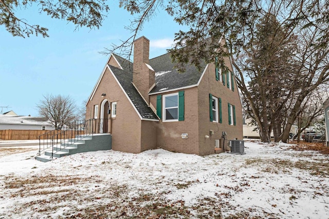 snow covered property with central AC unit