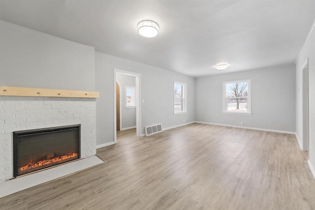 unfurnished living room featuring a brick fireplace and hardwood / wood-style floors