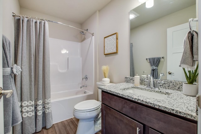 full bathroom featuring wood-type flooring, toilet, shower / bath combo with shower curtain, and vanity