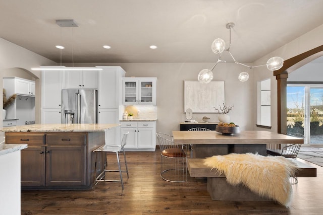 kitchen featuring white cabinetry, backsplash, high quality fridge, dark hardwood / wood-style flooring, and decorative light fixtures