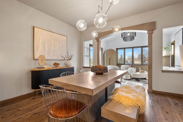 dining room with dark hardwood / wood-style flooring and ornate columns