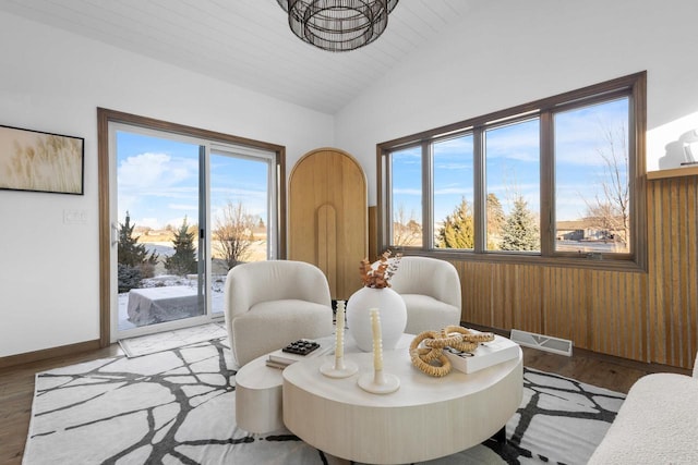 dining space featuring a healthy amount of sunlight, lofted ceiling, and hardwood / wood-style floors