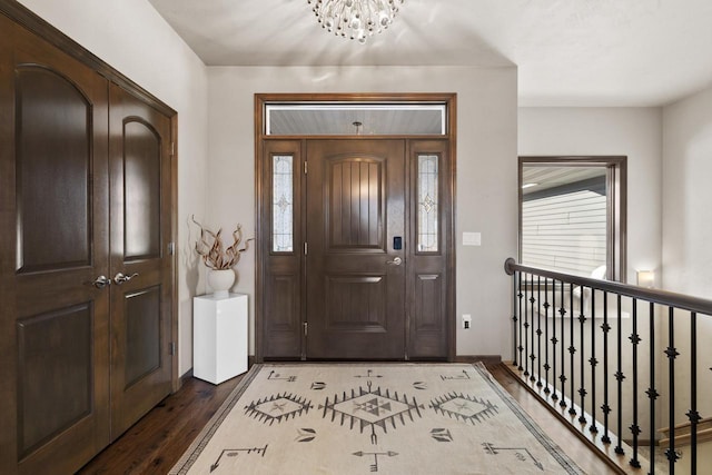 foyer with an inviting chandelier and dark hardwood / wood-style floors