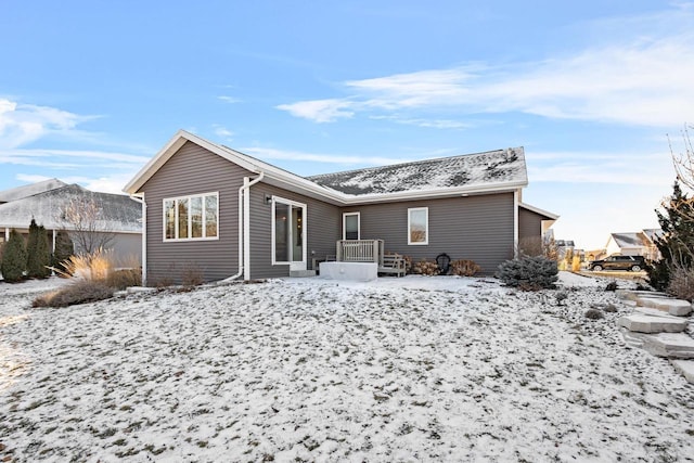 view of snow covered rear of property