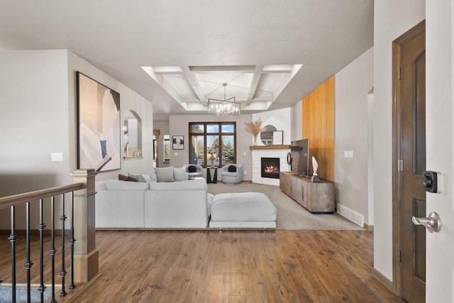 living room with coffered ceiling, hardwood / wood-style floors, a notable chandelier, and beamed ceiling