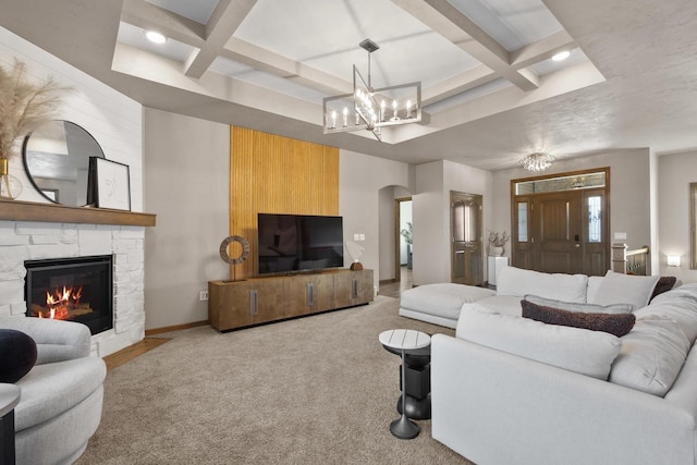 carpeted living room with coffered ceiling, a fireplace, beamed ceiling, and an inviting chandelier