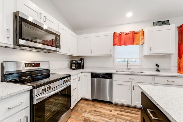 kitchen with appliances with stainless steel finishes, sink, and white cabinets