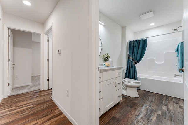 full bathroom featuring wood-type flooring, vanity, shower / tub combo with curtain, and toilet