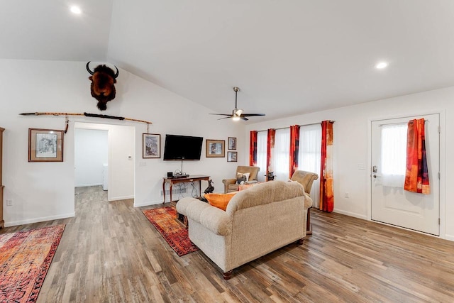 living room with hardwood / wood-style floors, vaulted ceiling, a barn door, and ceiling fan