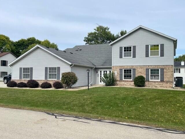 view of front of property with cooling unit and a front yard