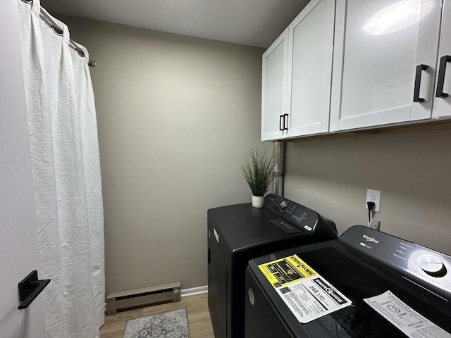 laundry area featuring cabinets, light hardwood / wood-style floors, independent washer and dryer, and baseboard heating