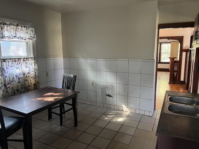 unfurnished dining area featuring tile walls, sink, and tile patterned floors