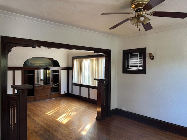 unfurnished room with crown molding, ceiling fan, wood-type flooring, and a textured ceiling