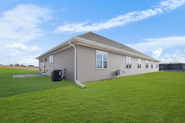 view of property exterior with a yard and central air condition unit