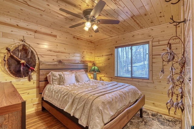 bedroom with wood ceiling, ceiling fan, wooden walls, and hardwood / wood-style floors