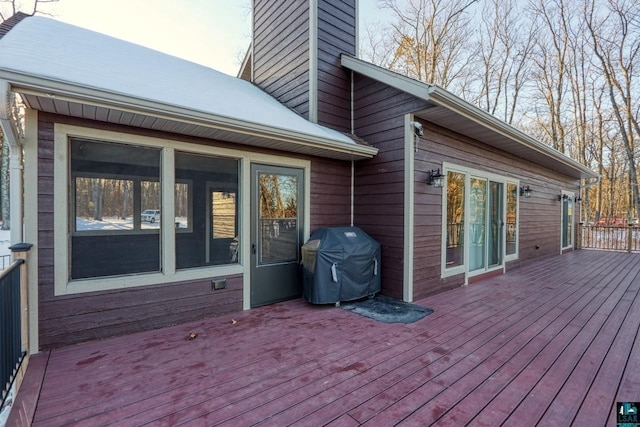 wooden terrace featuring a sunroom and area for grilling