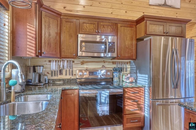 kitchen featuring dark stone countertops, sink, backsplash, and appliances with stainless steel finishes