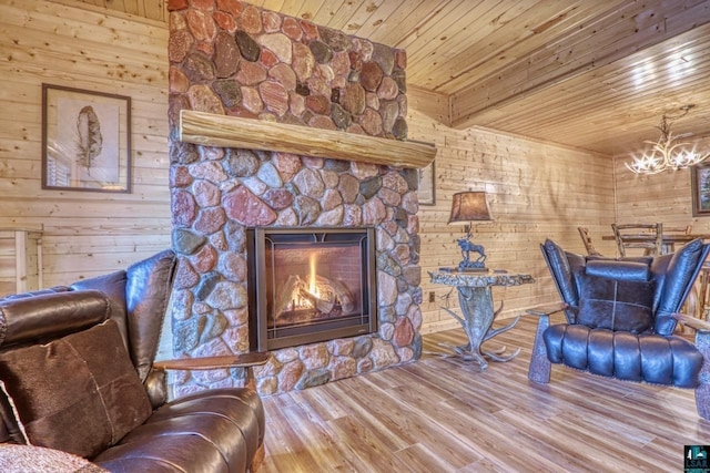 unfurnished room featuring wood walls, an inviting chandelier, wooden ceiling, hardwood / wood-style flooring, and a fireplace