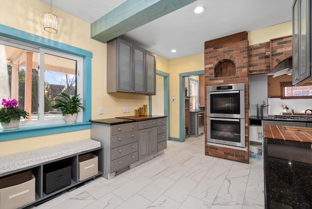 kitchen featuring hanging light fixtures, gray cabinets, and double oven