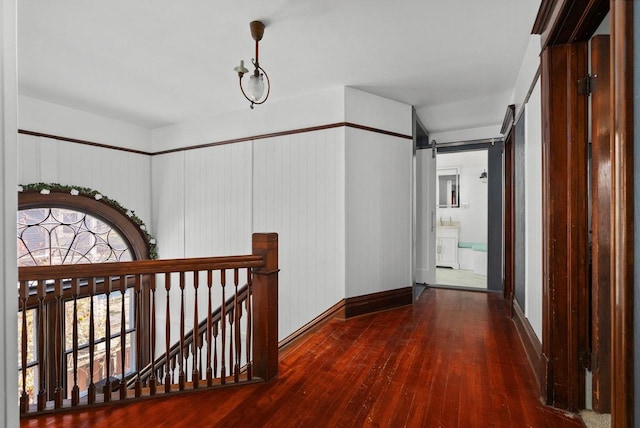 hall featuring dark wood-type flooring and a barn door